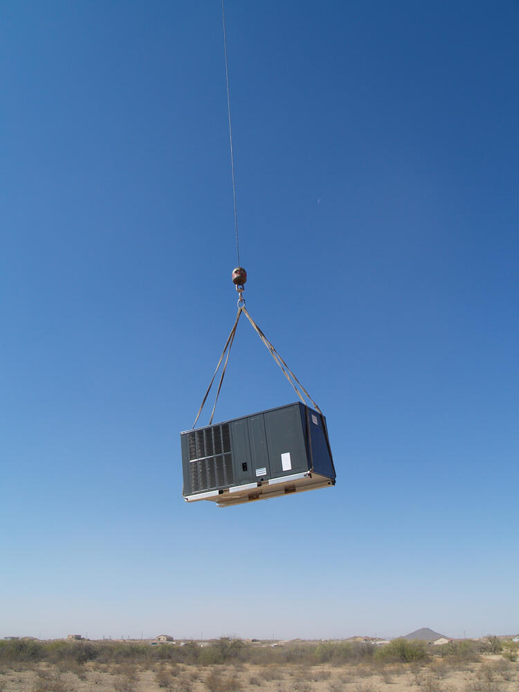HVAC unit being lifted by crane
